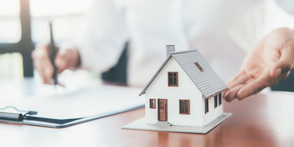 House model with real estate agent and customer discussing for contract to buy house, insurance or loan real estate background.