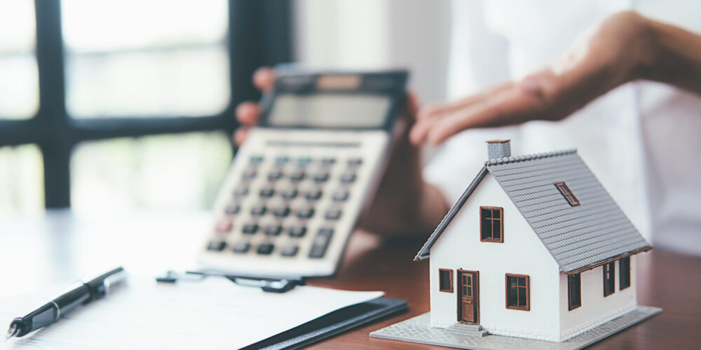 House model with real estate agent and customer discussing for c House model with real estate agent and customer discussing for contract to buy house, insurance or loan real estate background.